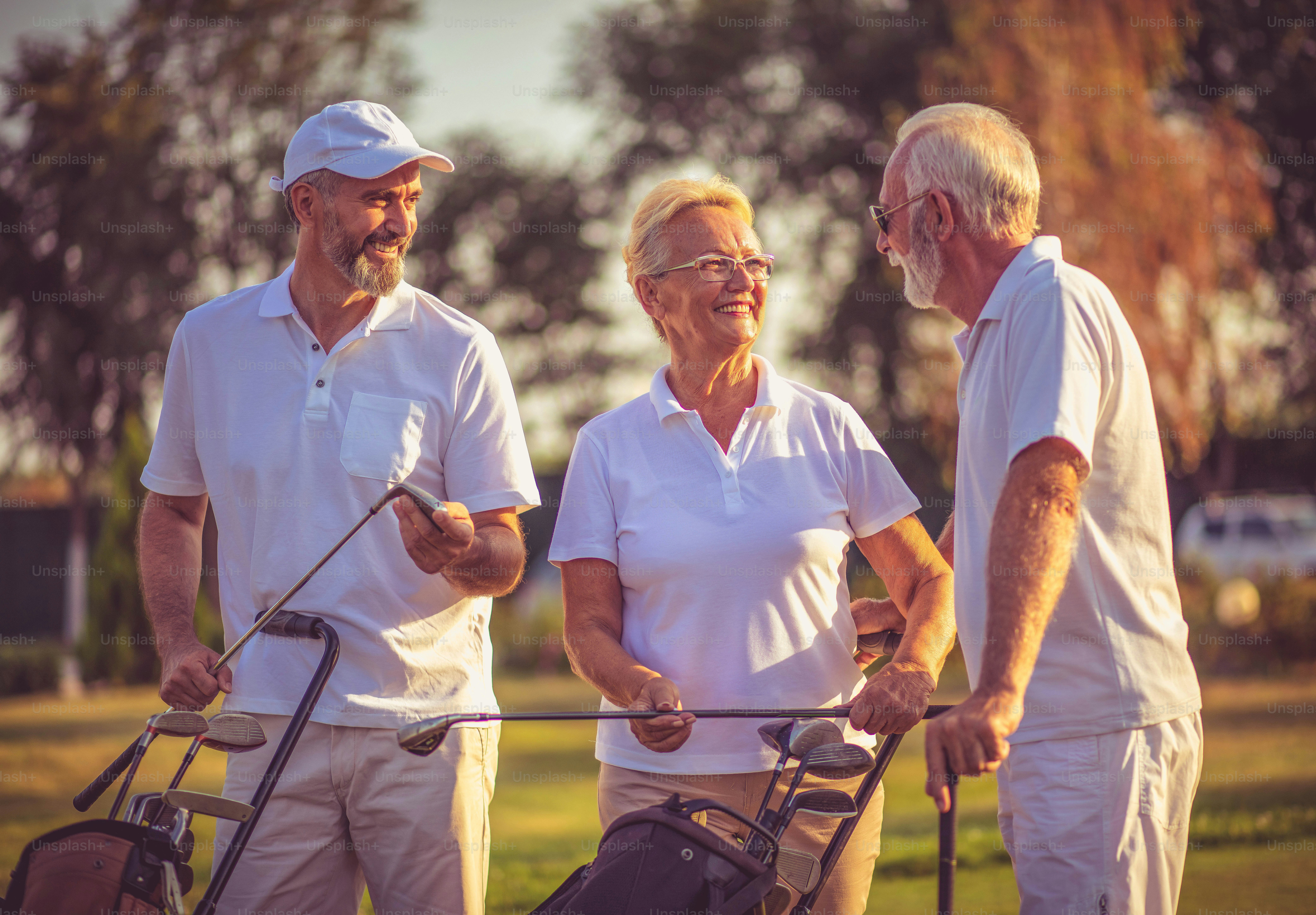 Senior friends on golf court talking.